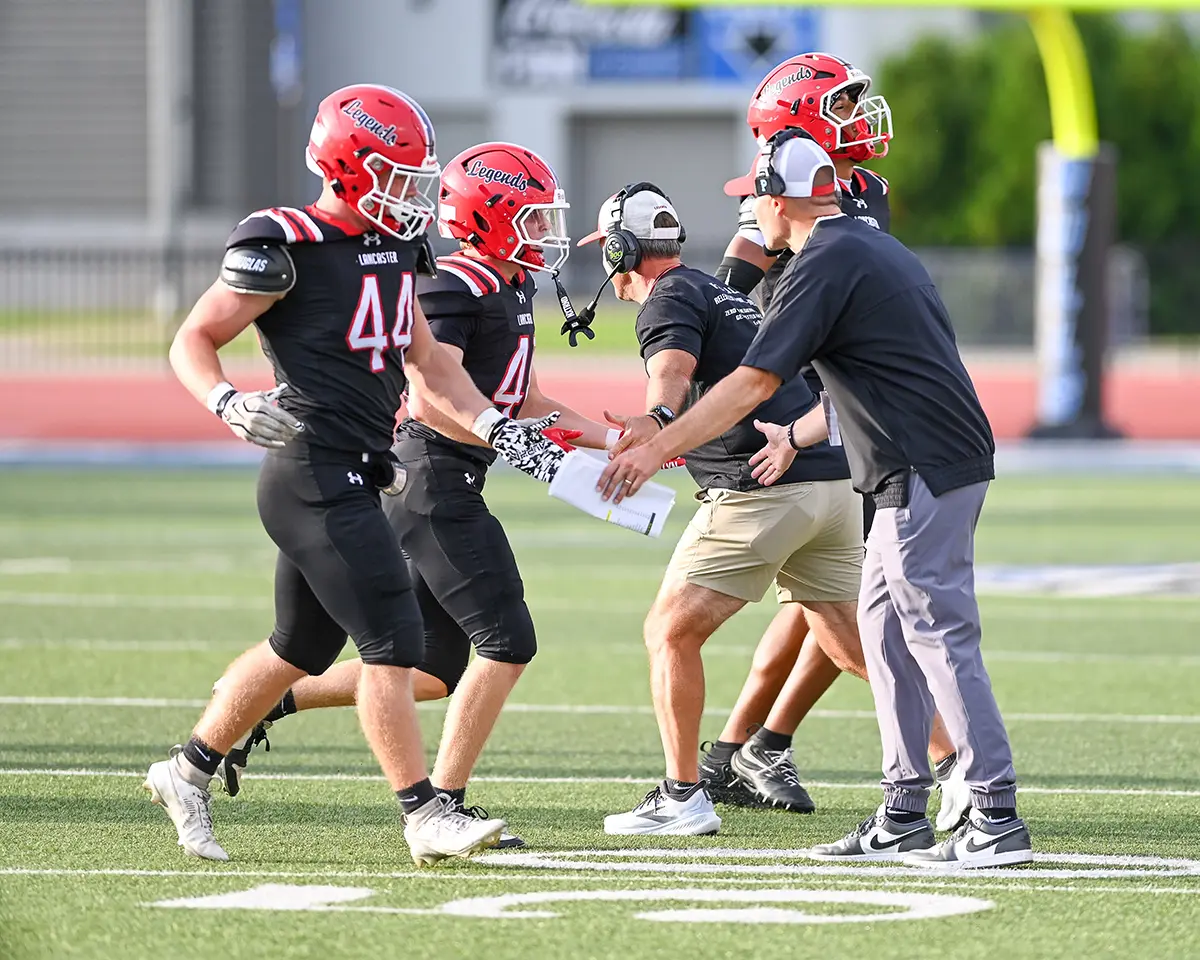 Lancaster Staff giving fives to the team as they come off the field